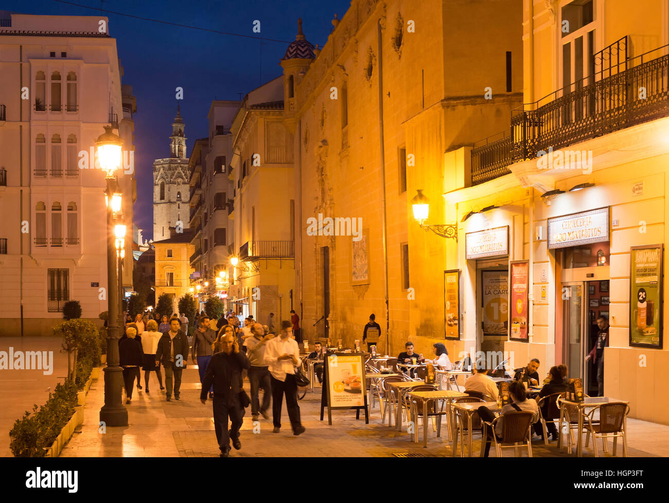 People walking and sitting in a restaurant on Old Town street of Valencia. Valencia is the 3rd largest city in Spain. Stock Photo