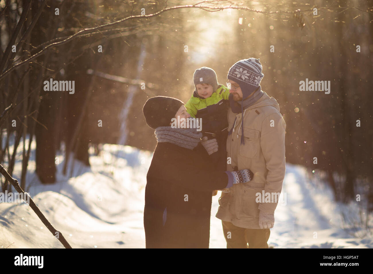 happy family in a winter suits, sunshine, snowfall Stock Photo Alamy