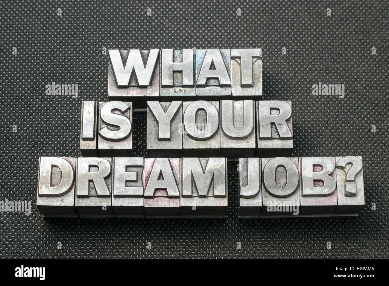 what is your dream job question made from metallic letterpress blocks on black perforated surface Stock Photo