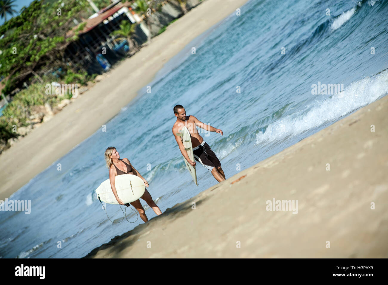 Surfers walking on the beach, Isabela, Puerto Rico Stock Photo