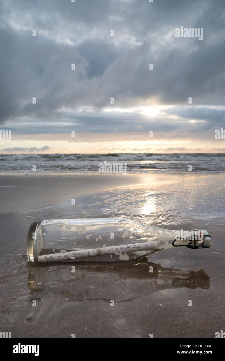 message in a bottle stranded on the beach Stock Photo