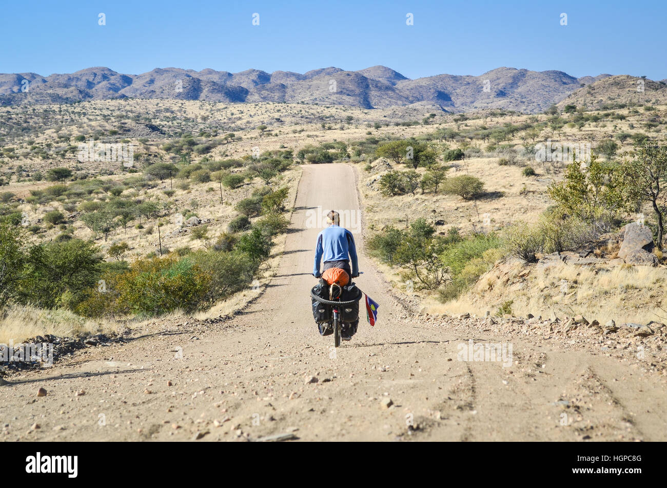 Cyclist on the C28 gravel road to Windhoek, Namibia Stock Photo