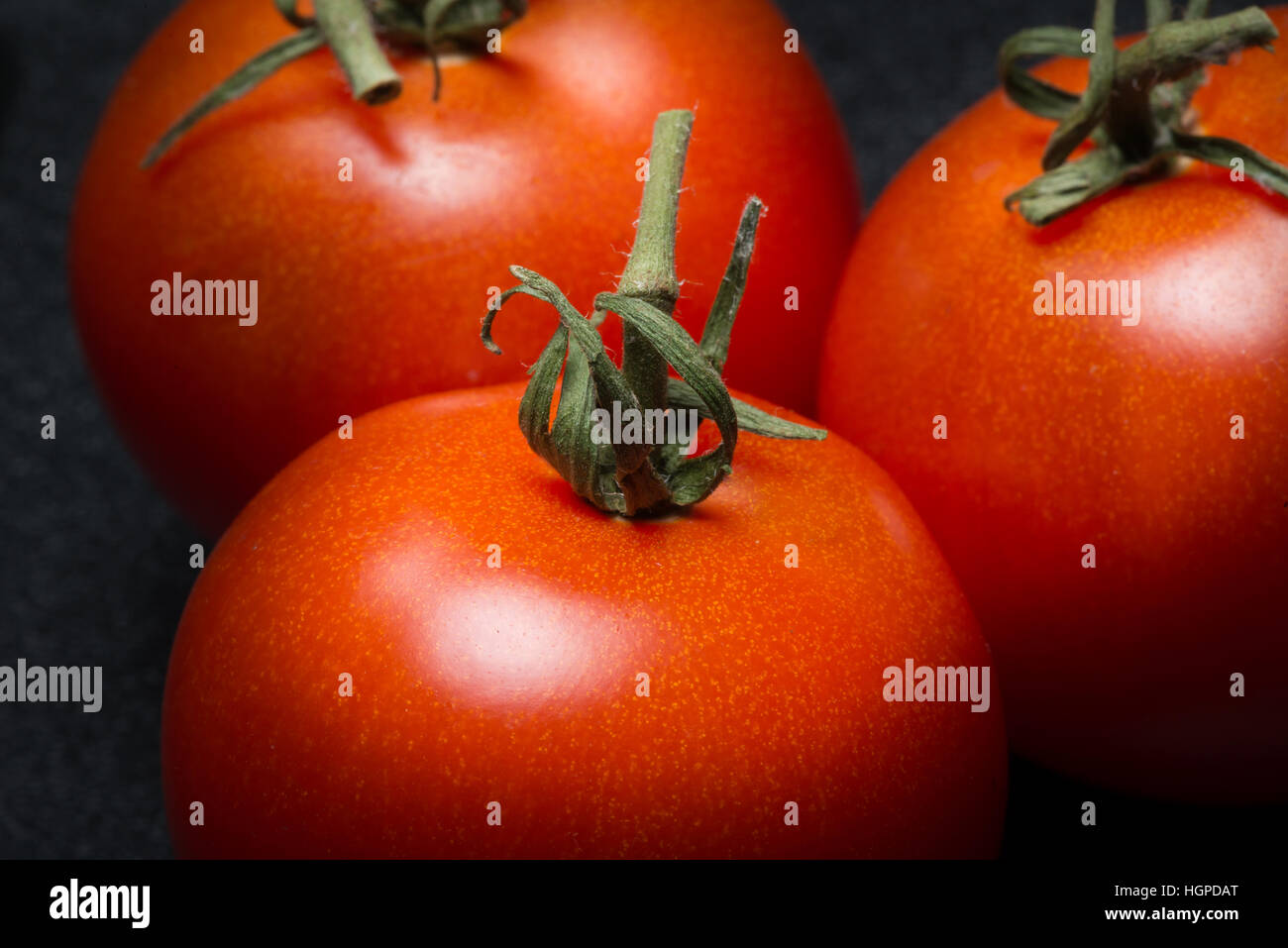 Red ripe tomatoes on black background Stock Photo - Alamy