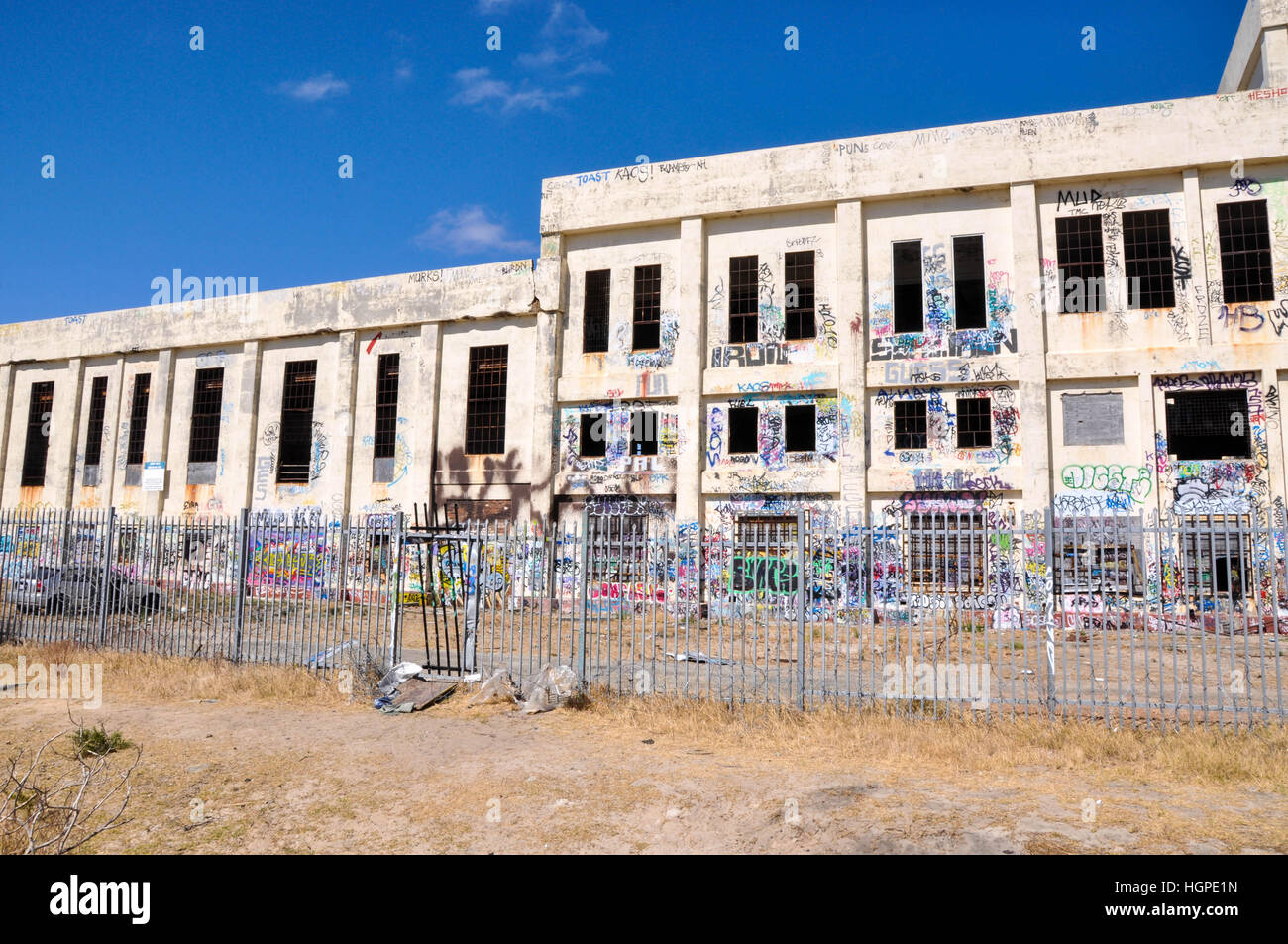 Old abandoned South Fremantle Power Station with youth tagging, broken windows and fence line in