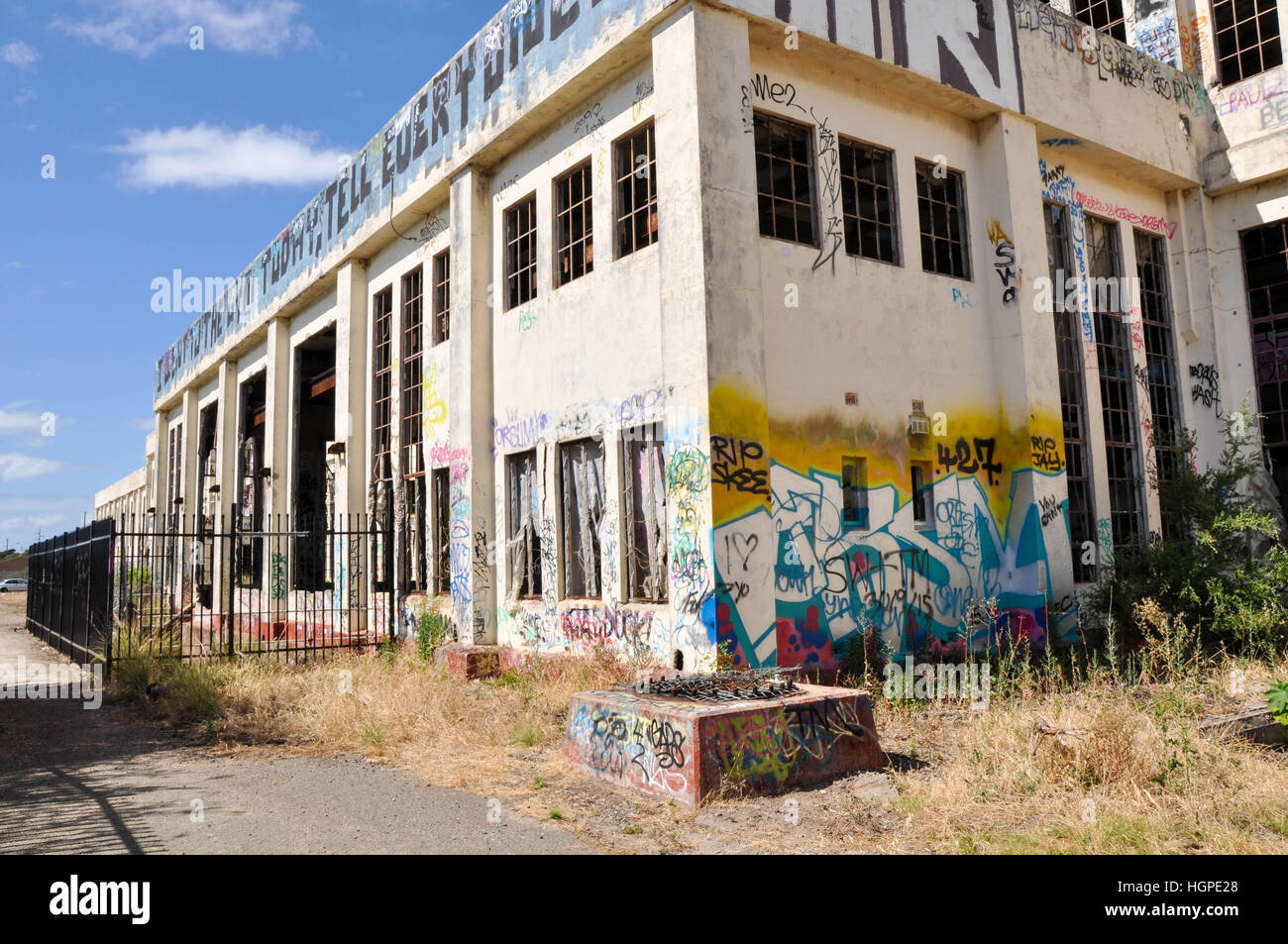 Old abandoned South Fremantle Power Station with youth tagging, broken windows and fence in