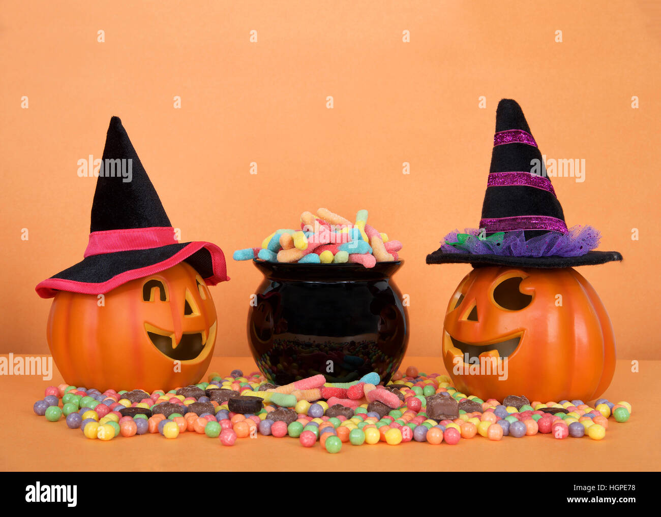 Halloween candy worms spilling from a black cauldron with hard candies
