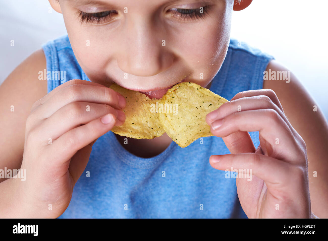 Little boy eating potato chips closeup Stock Photo