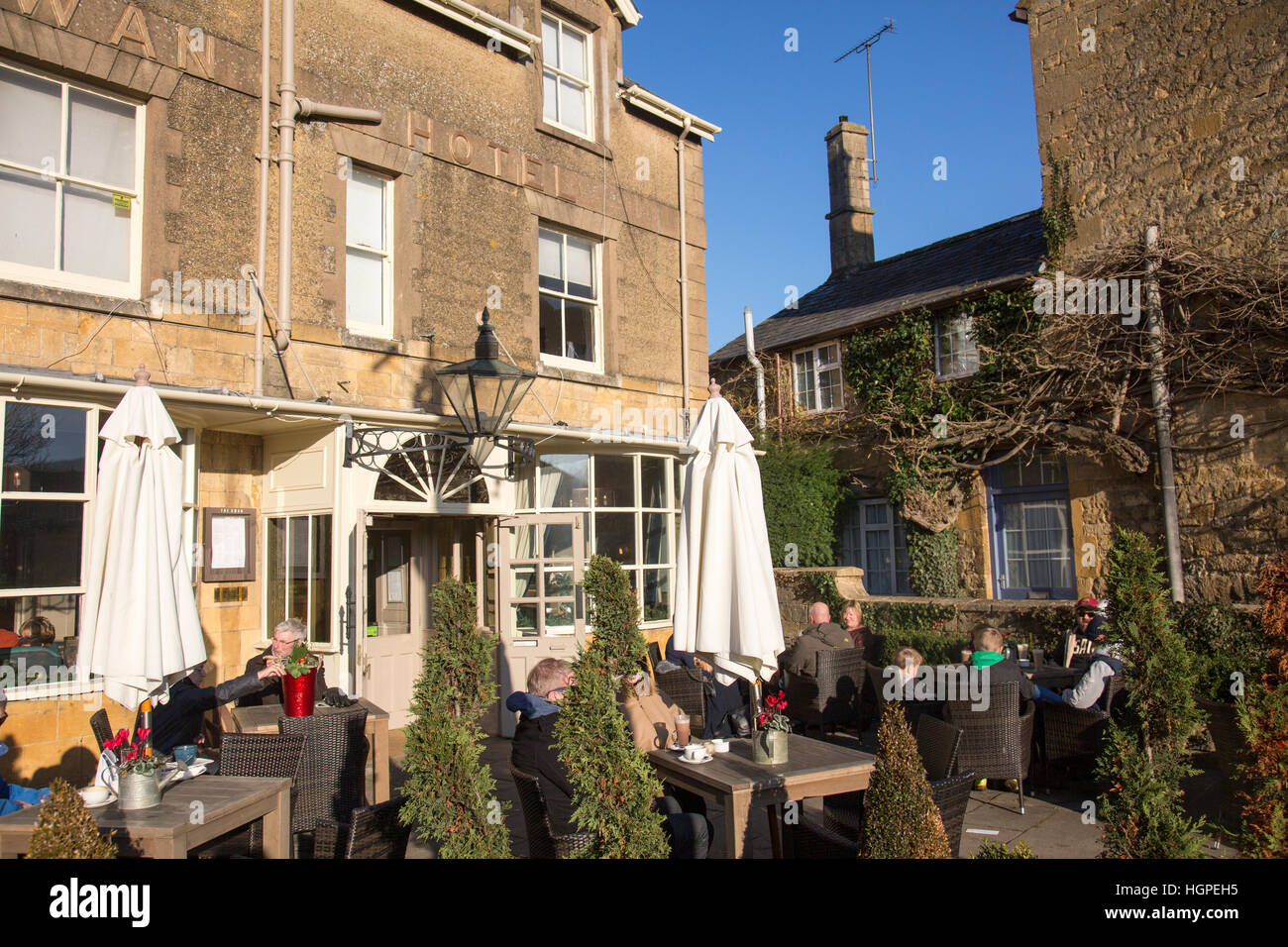 people eating outside on a winters day at the Kings Arms in the Cotswold village of Broadway,Worcestershire ,England Stock Photo
