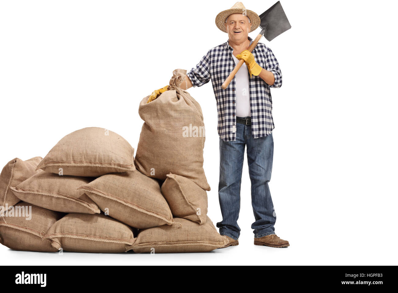 Full length portrait of a mature farmer with a shovel standing next to ...