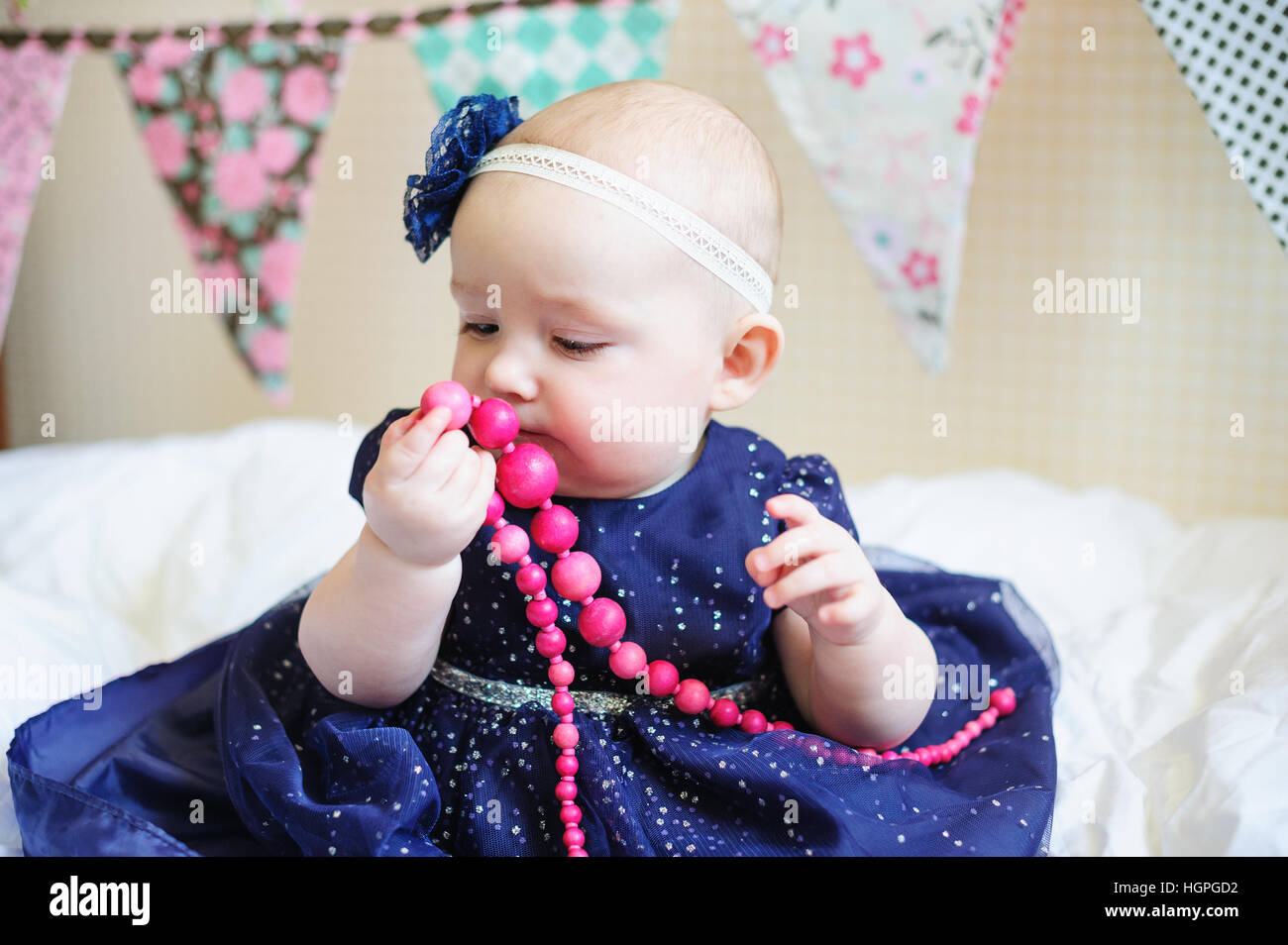 little baby girl in blue dress with pink beads Stock Photo - Alamy