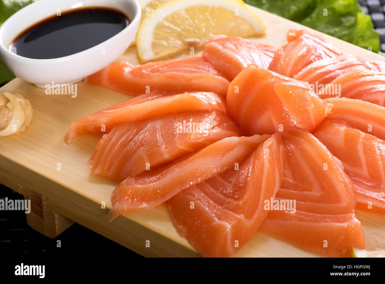 Presentation of raw fresh salmon sashimi sliced thinly and arranged in