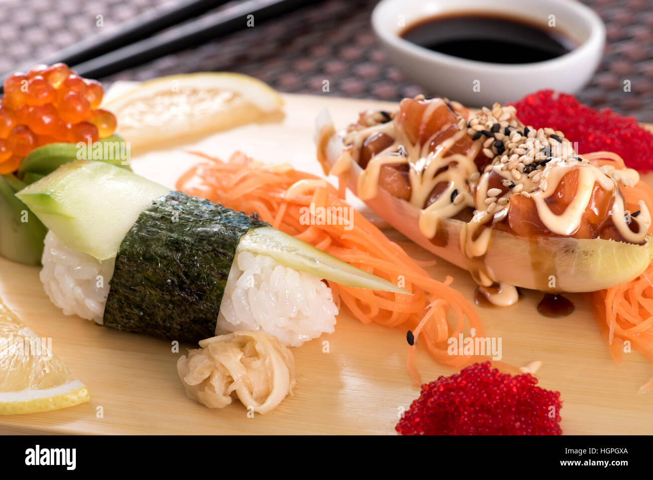 Japanese cuisine sushi set with salmon fish served with tartar sauce on wooden board, close up view Stock Photo