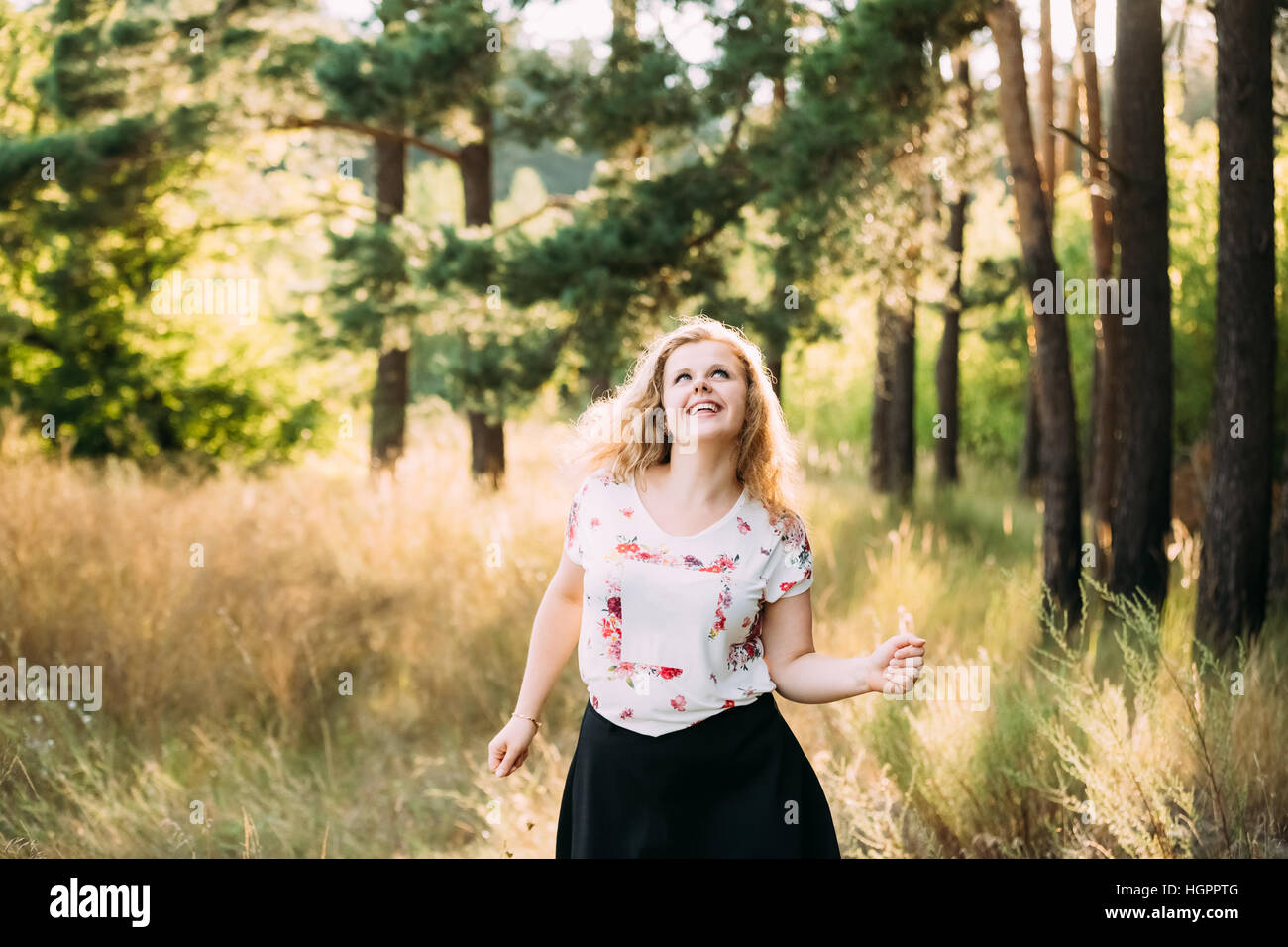 Single Young Pretty Plus Size Caucasian Happy Smiling Laughing Girl Woman In White T-Shirt, Dancing In Summer Green Forest. Fun Enjoy Outdoor Summer N Stock Photo