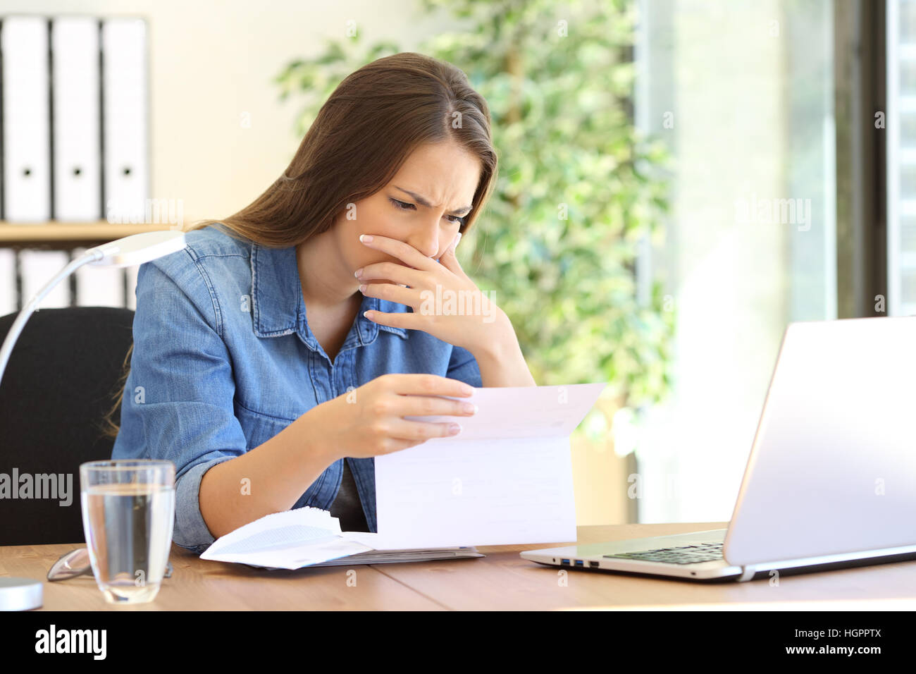 Worried entrepreneur girl working at office reading bad news in a ...
