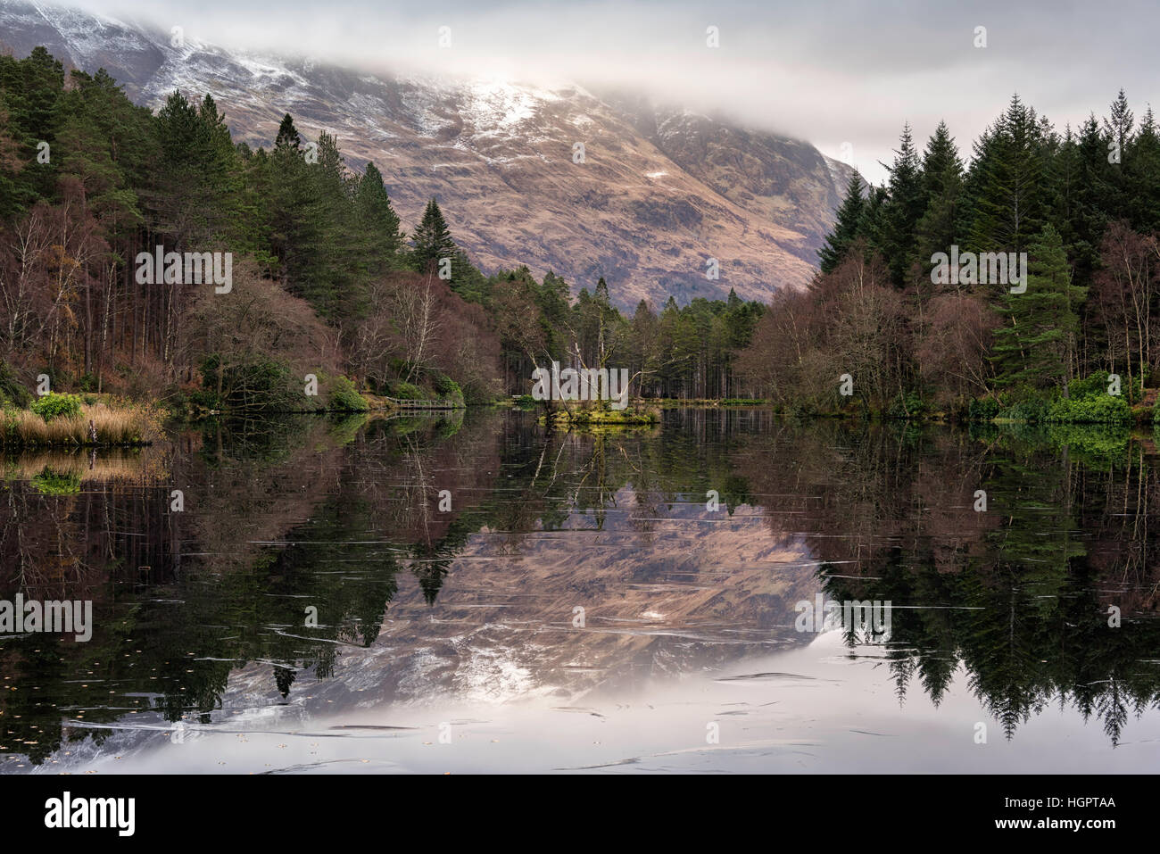 Glencoe Lochan covered in ice producing mirror like reflections, Scotland, UK Stock Photo