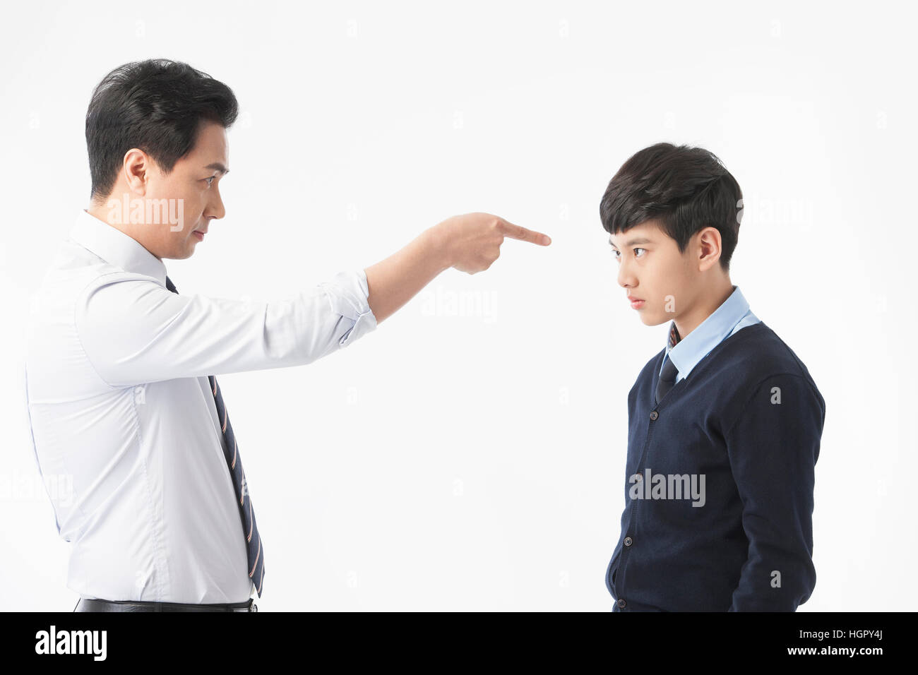 Side view of teacher scolding and stressful school boy Stock Photo