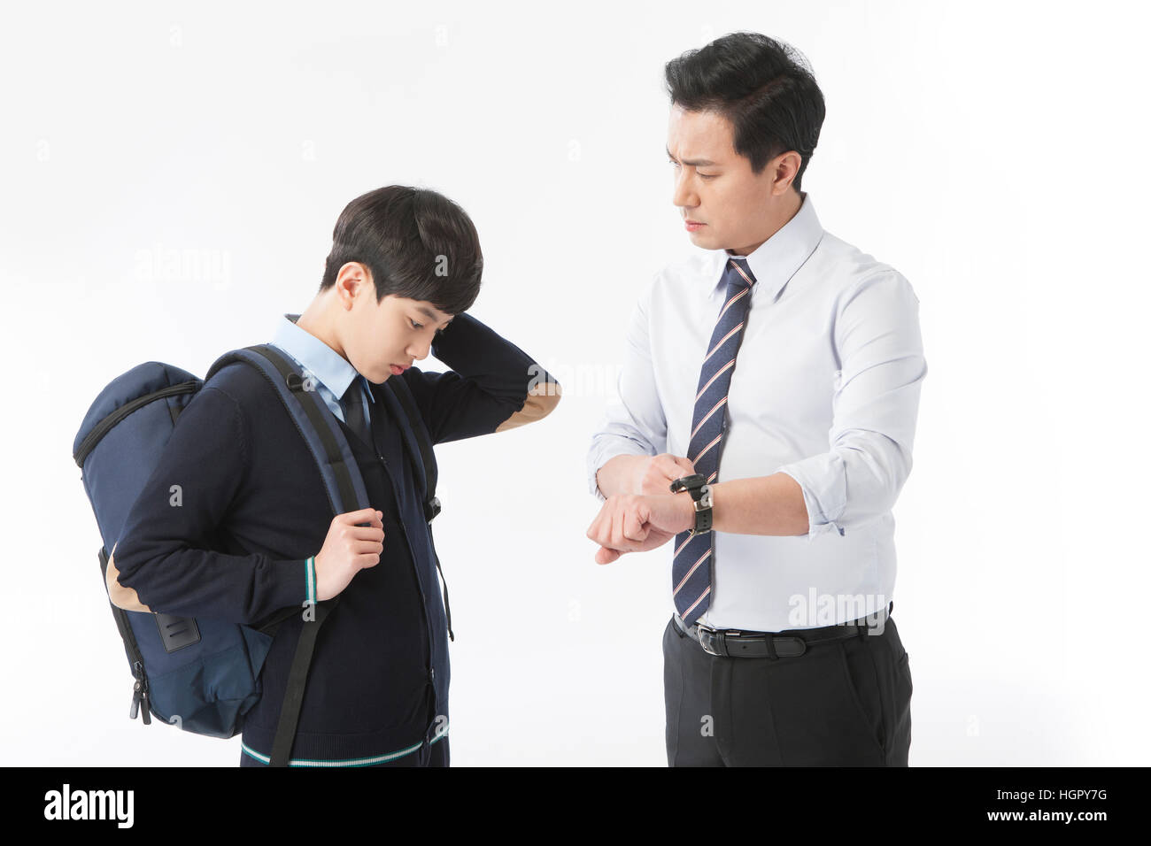 Teacher scolding a school boy for being late Stock Photo