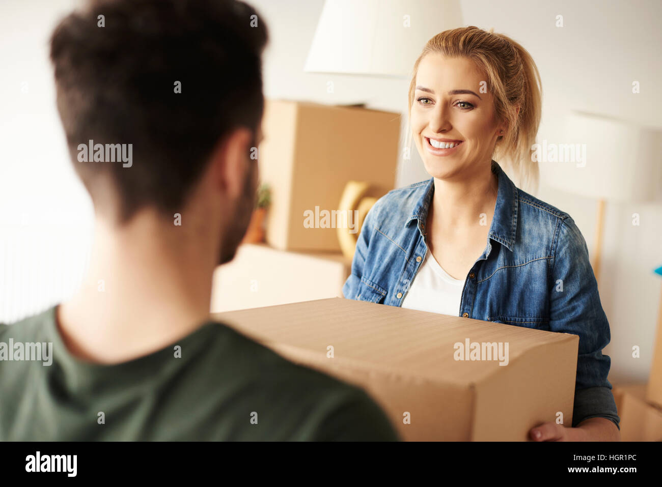 Woman passing cardboard box to her partner Stock Photo