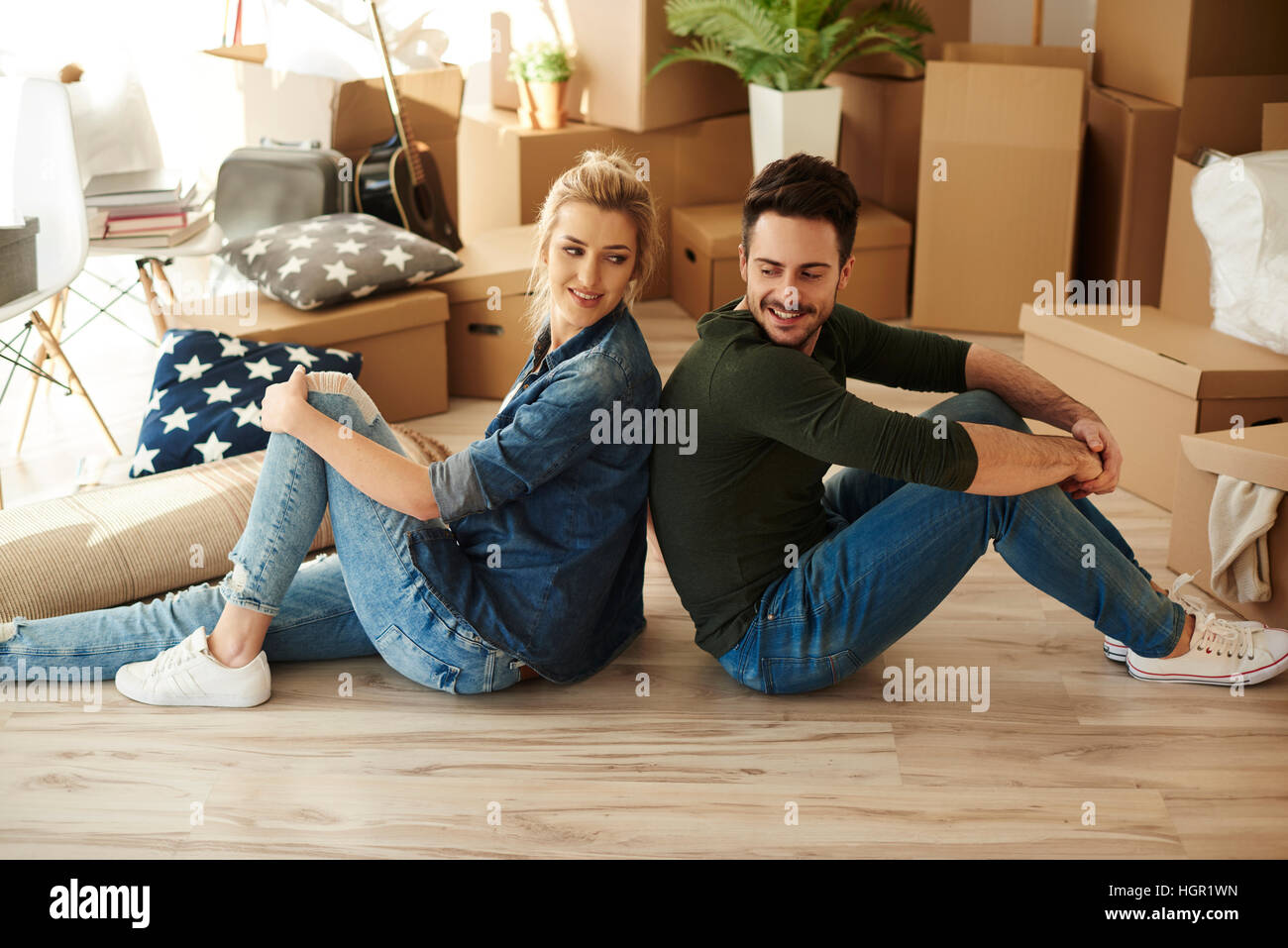 Side view of couple sitting back to back Stock Photo