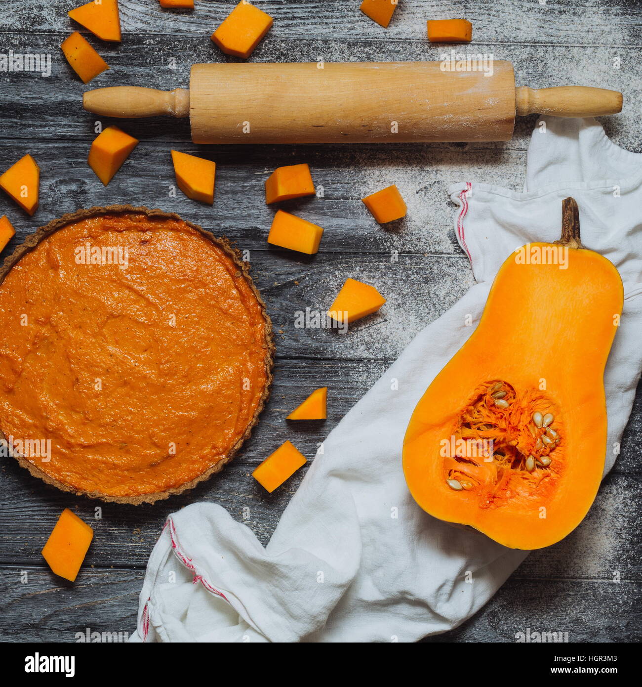 Overhead shot of pumpkin pie, butternut squash pumpkin pieces, rolling