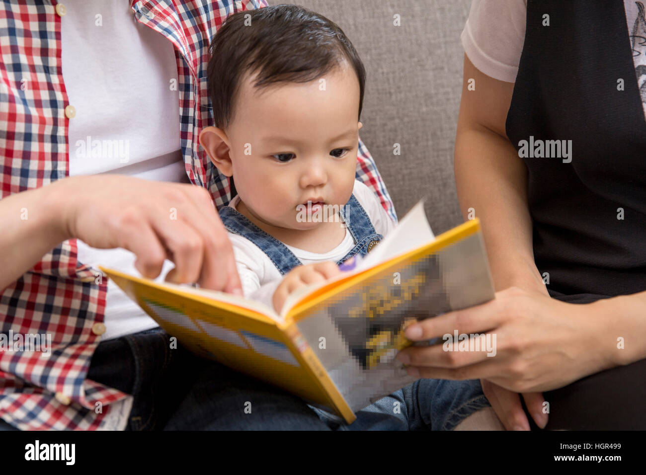 Parents reading book to their baby stock photo alamy