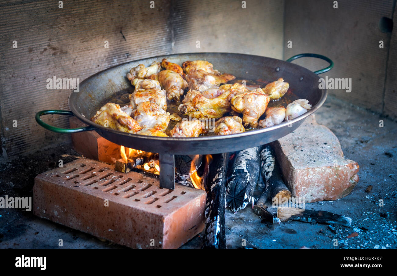 Cooking and making a traditional Spanish Paella over open fire with