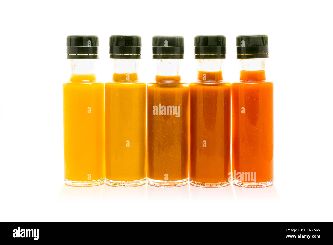 Different color home made hot sauce in glass bottles. Yellow, brown