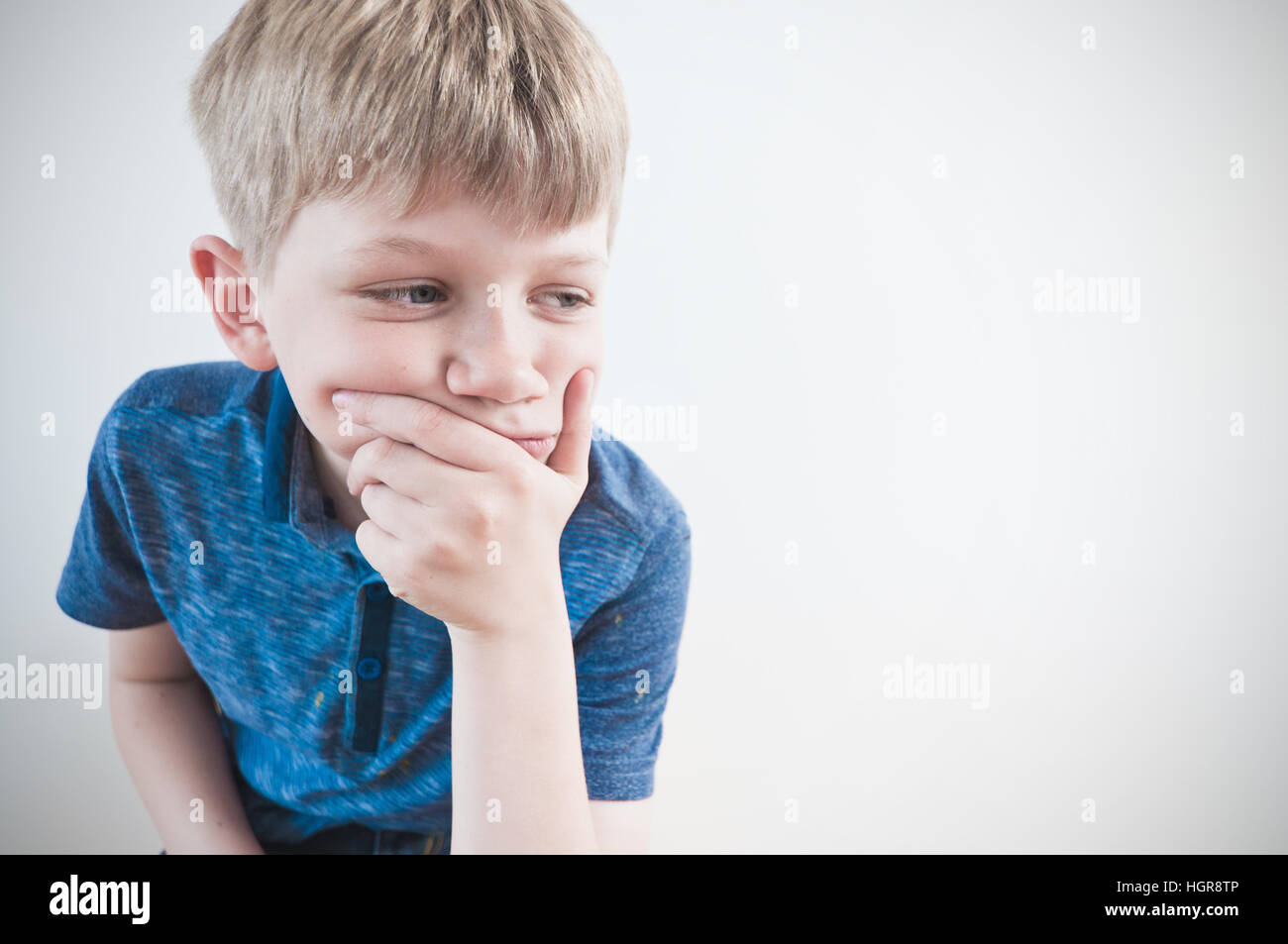 Worried child deep in thought copy space to the right of the image Stock Photo