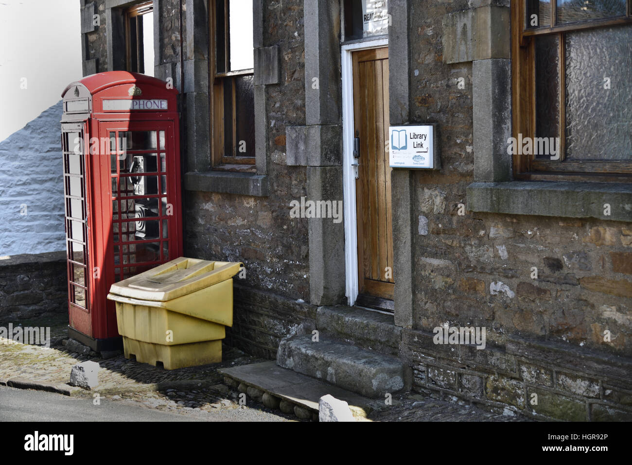 Dent library, red phone box, yellow grit bin, Dent village, Yorkshire Dales National Park, Cumbria, England, UK. Stock Photo