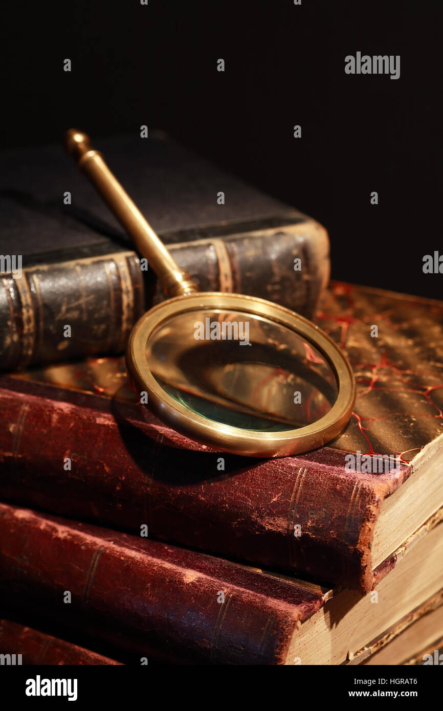 Vintage library. Closeup of magnifying glass on old book Stock Photo