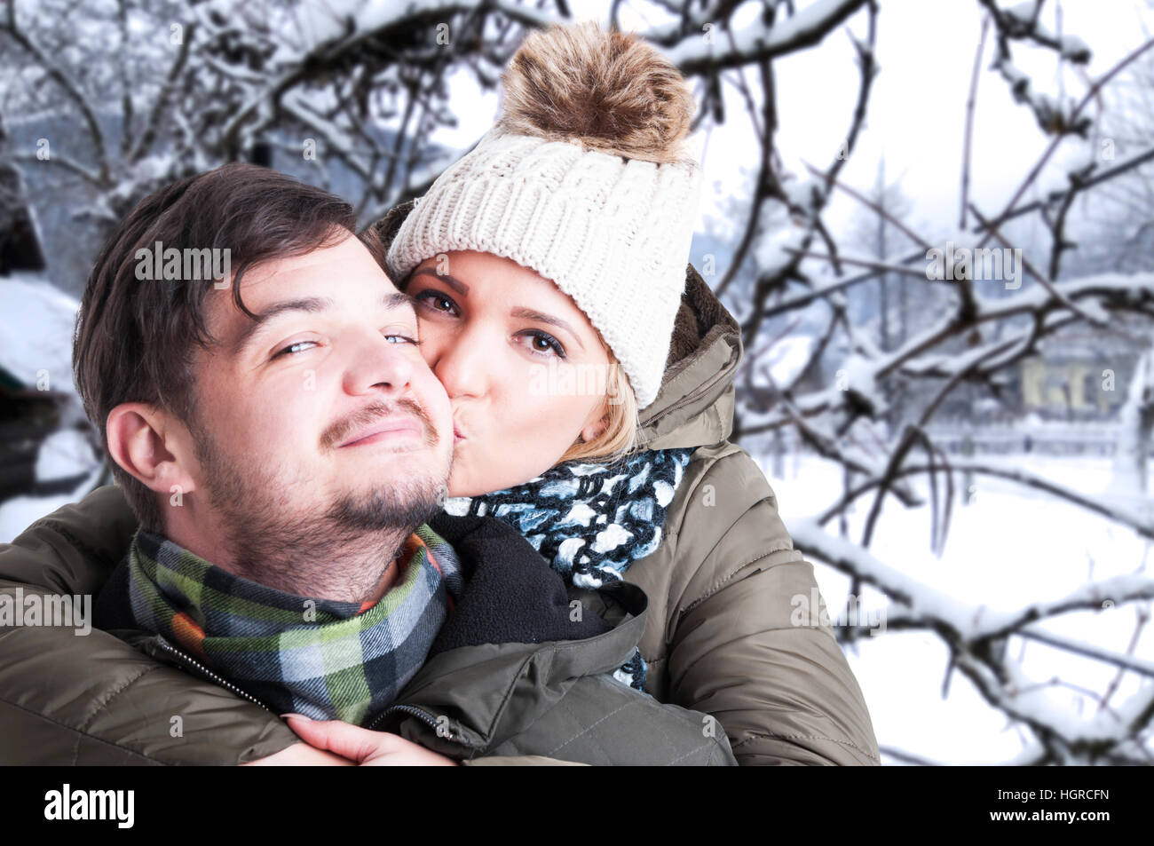Beautiful woman in winter forest hugging and kissing her boyfriend ...