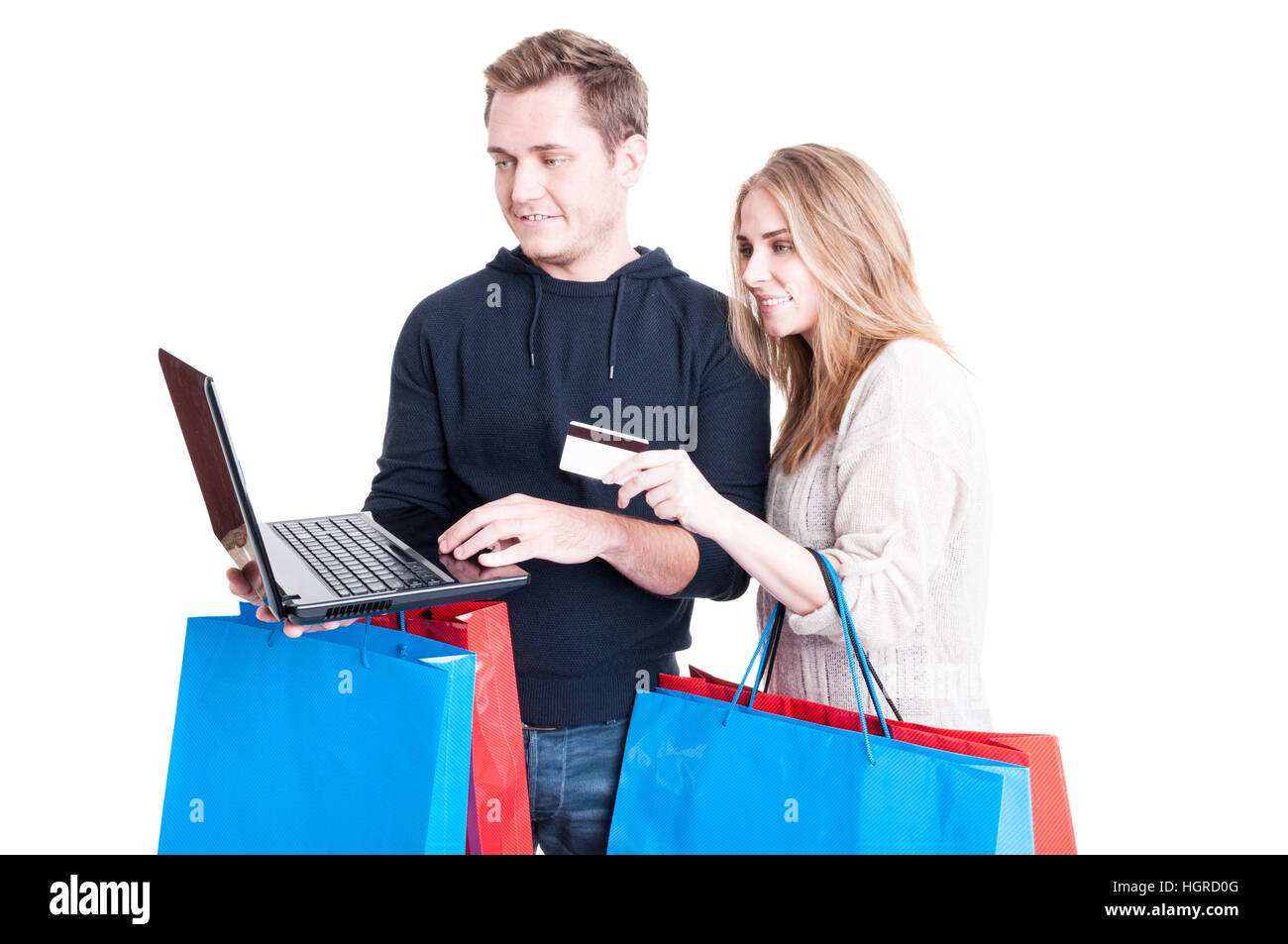Couple holding shopping bags and paying online with credit card on laptop isolated on white background Stock Photo