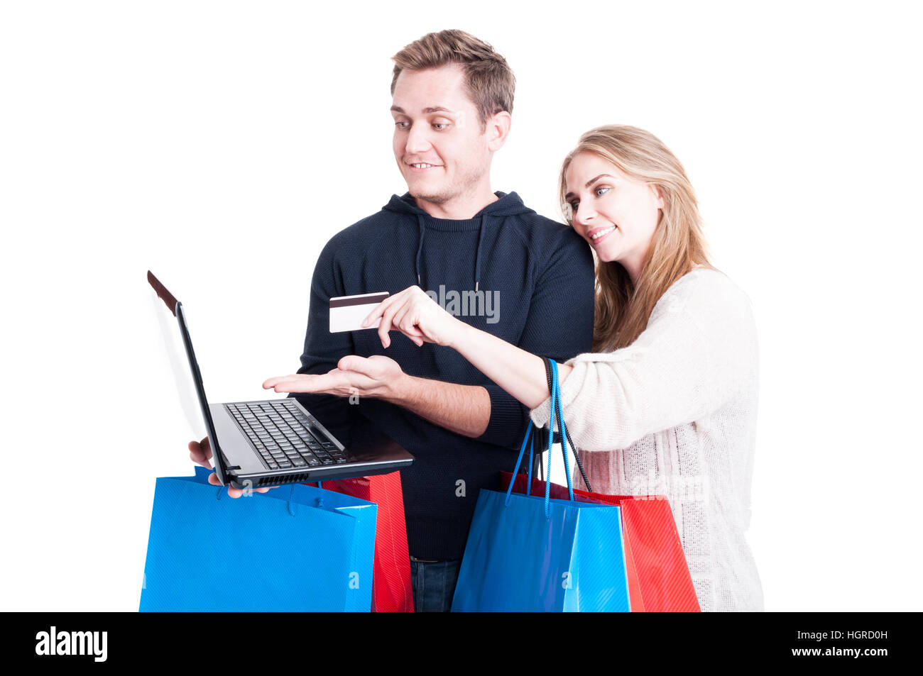 Couple holding shopping bags and paying online with credit card on laptop isolated on white background Stock Photo