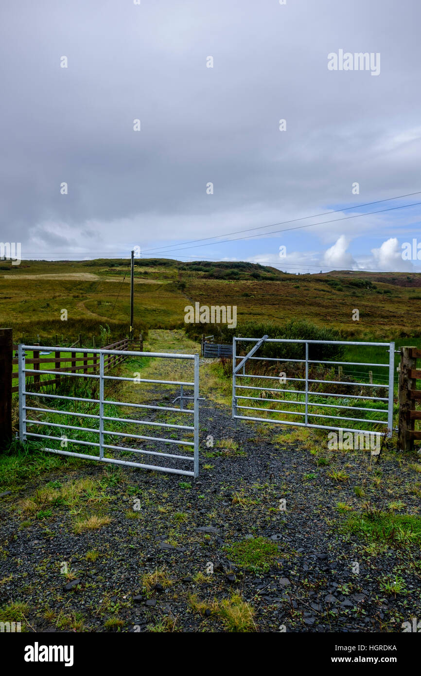 Open metal farm gate leading to rural countryside landscape in Isle of Skye Scotland Stock Photo