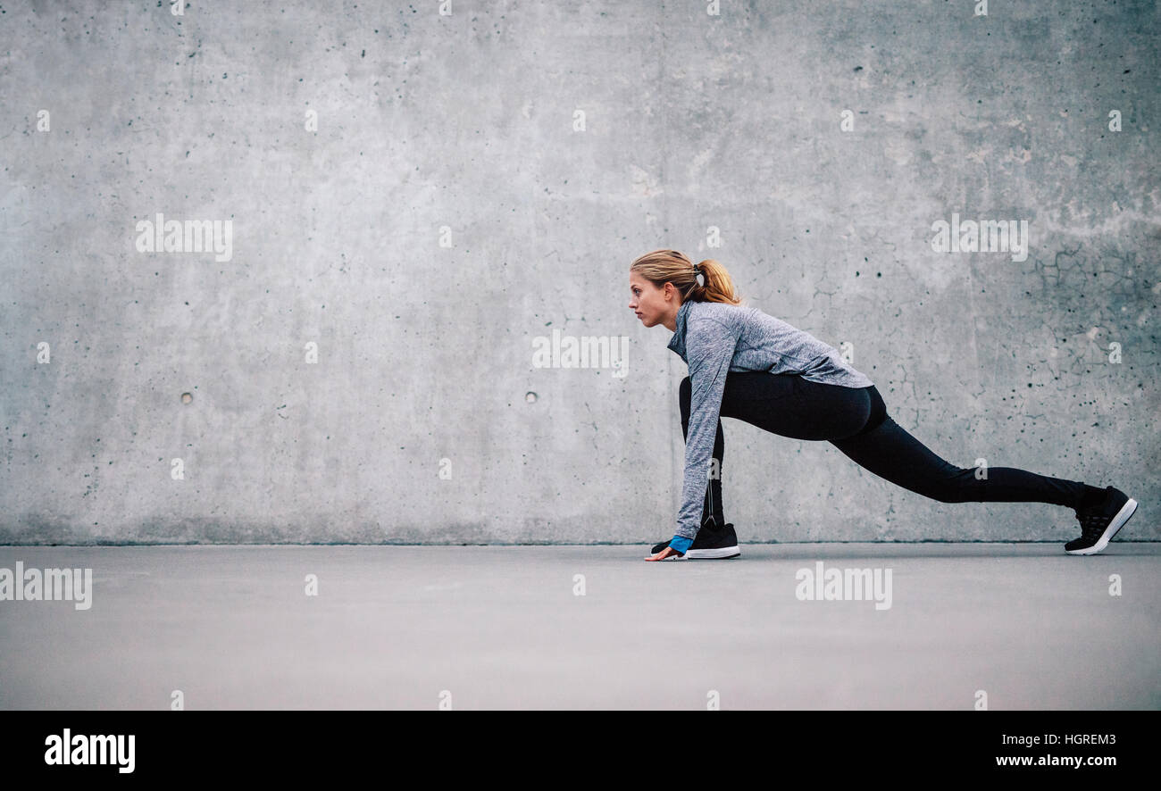 Full length shot of fit young woman doing stretching workout. fitness model exercising in morning outdoors. Stock Photo