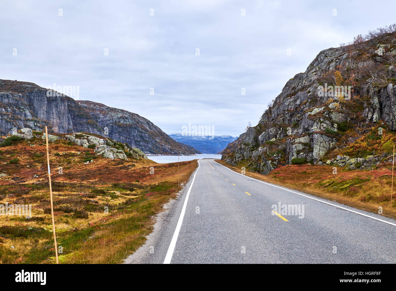 The road on route 45 in Rogaland, Norway, turns right along a tarn between the fells Stock Photo
