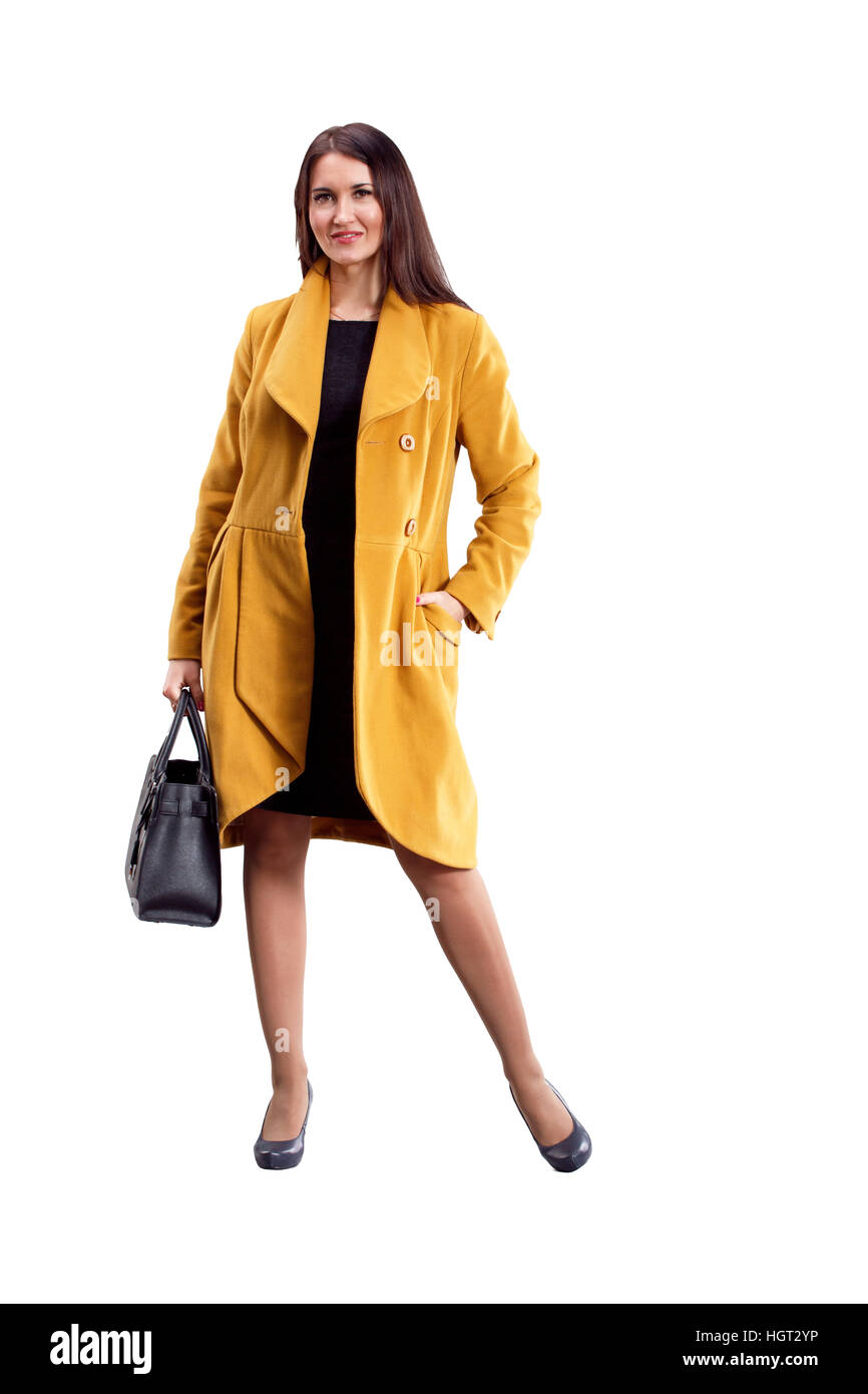 Portrait of fashion girl in yellow coat posing on light background ...