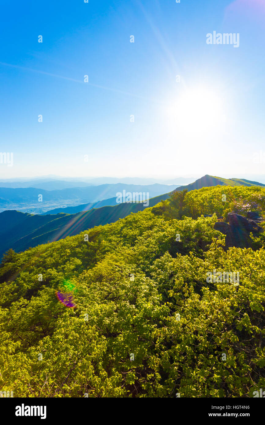 View from Jirisan Mountain viewpont to valley below, looking into the sun on a clear, spring day in South Korea. Vertical Stock Photo