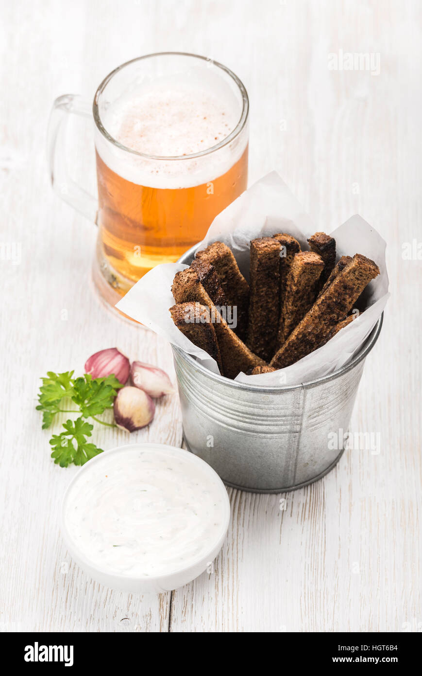 Beer snack set. Pint of pilsener in mug and rye bread croutons with