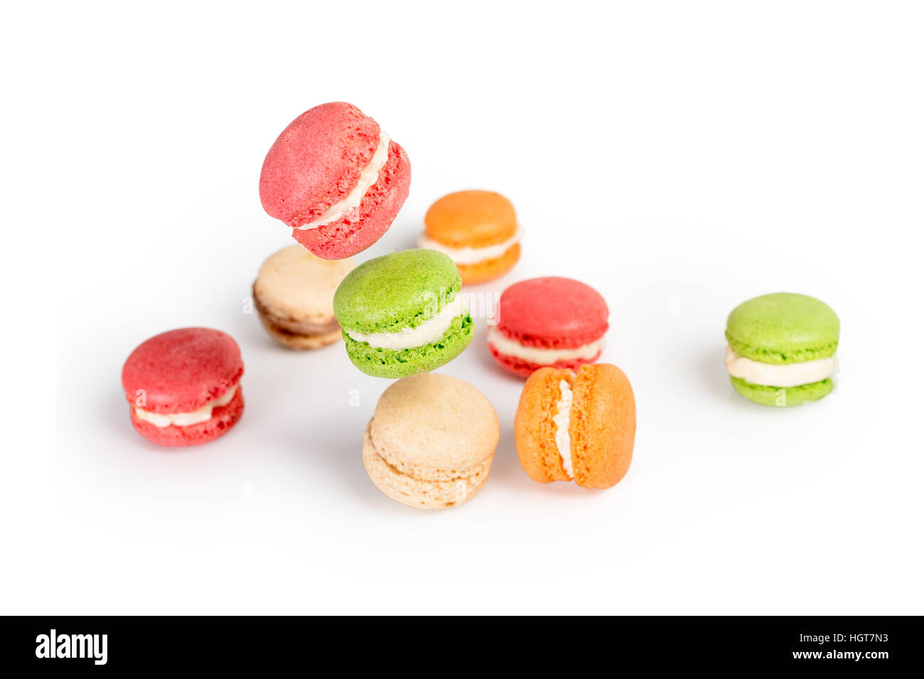 Different types of macaroons in motion falling or flying on white ...