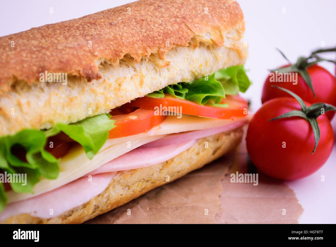 Fresh crusty baguette with ham, cheese, tomato and green salad Stock
