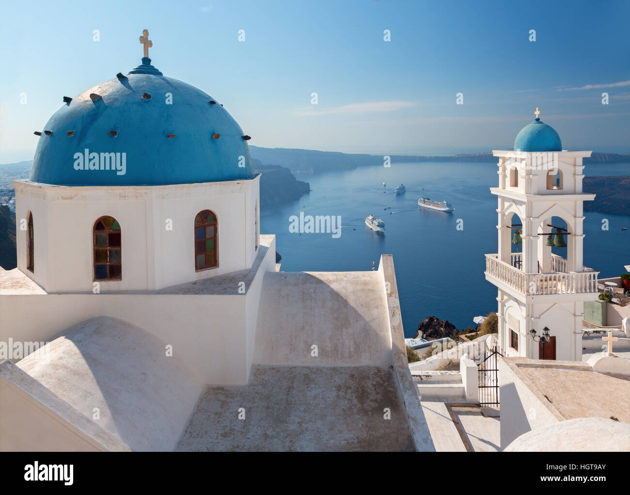 Santorini - The tower of Anastasi church in Imerovigli with the cruises in background. Stock Photo