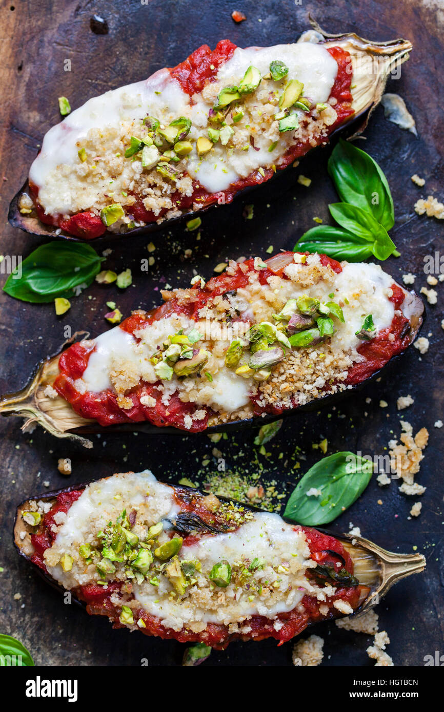 Roast aubergines with tomatoes mozzarella and pistachio nuts Stock