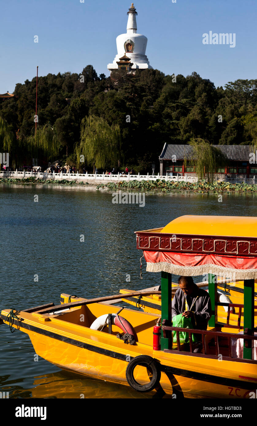 Water taxis moored on the lake in Beihai Park with the White Dagoba visible, Beijing, China Stock Photo