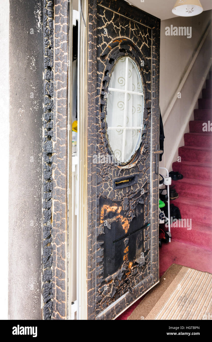 UPVC front door seriously damaged in a rascist arson attack. Stock Photo