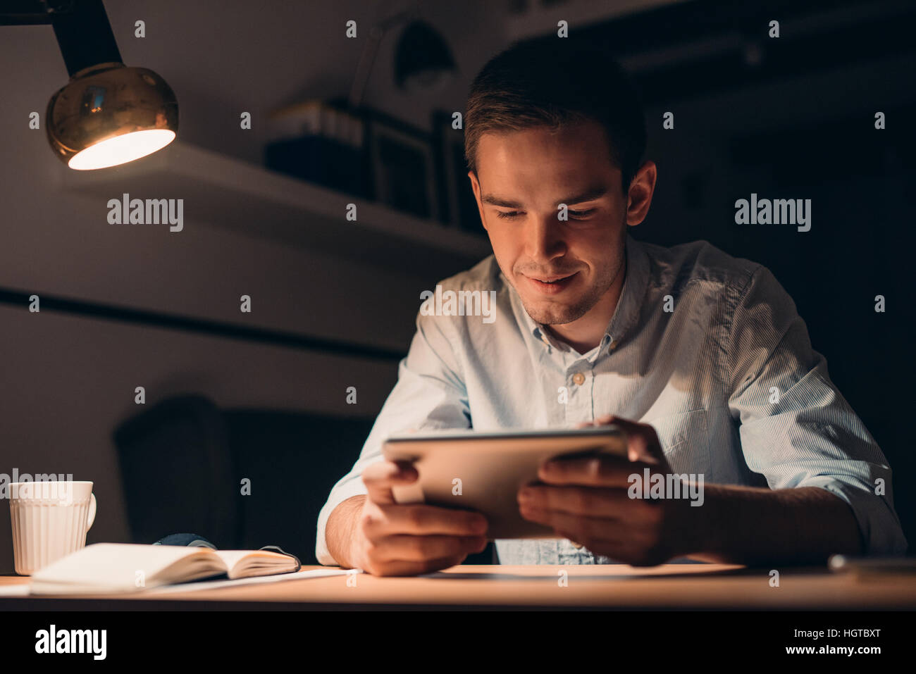 Young businessman working using a tablet late at night Stock Photo - Alamy