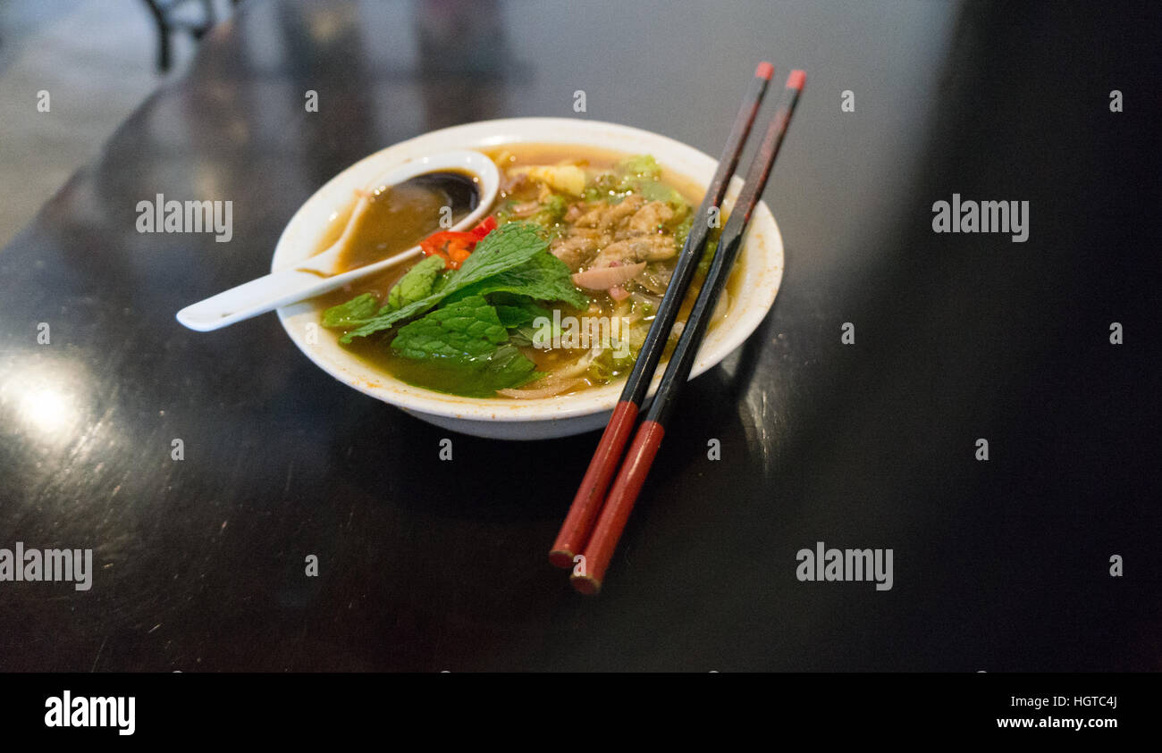 Delicious Asam Laksa with a red pair of chopsticks in Penang, Malaysia Stock Photo