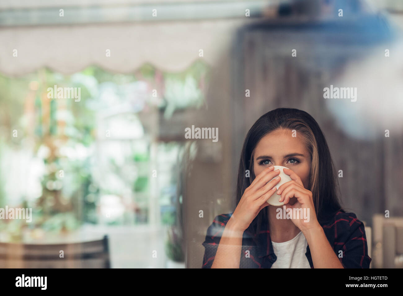 Young woman deep in thought drinking a coffee Stock Photo