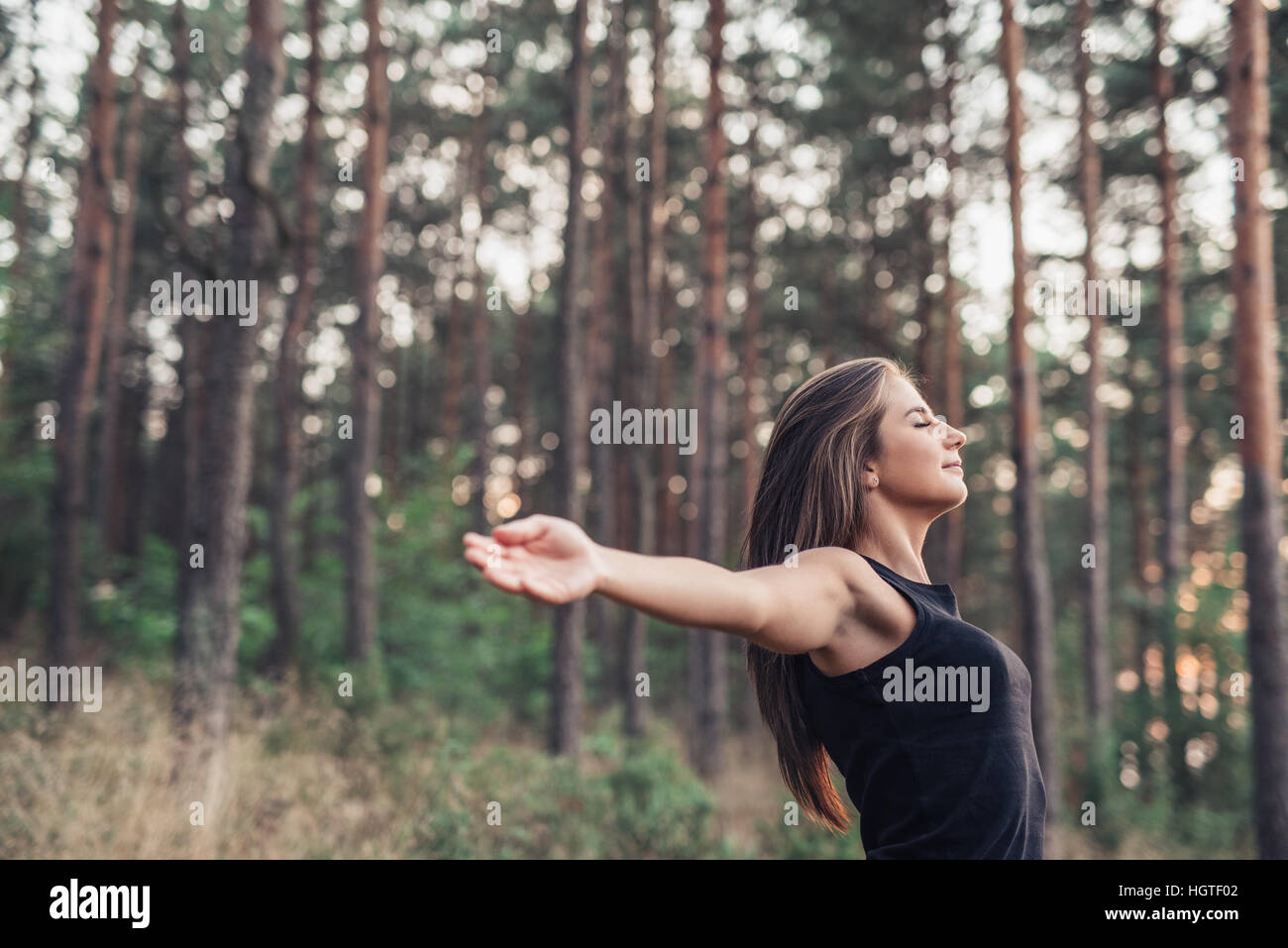 Young woman raising her arms to nature Stock Photo