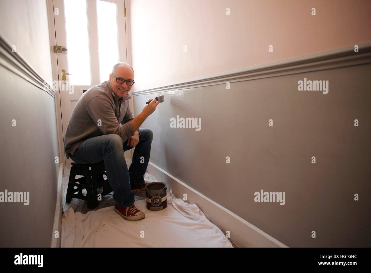 Middle aged man painting the inside off his house. Stock Photo